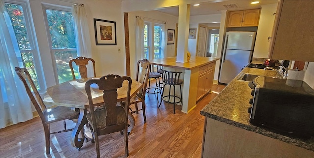 dining area with sink and light wood-type flooring