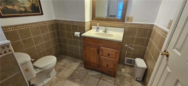 bathroom with tile walls, vanity, and toilet