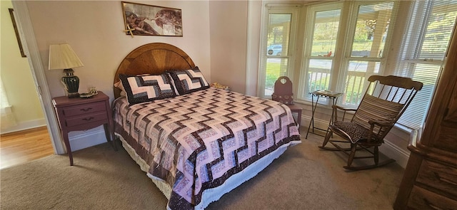 bedroom featuring multiple windows and hardwood / wood-style flooring