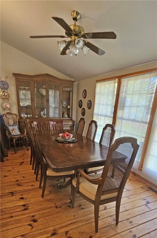 dining space featuring ceiling fan, lofted ceiling, and light hardwood / wood-style flooring