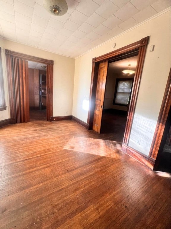 unfurnished room featuring crown molding and wood-type flooring