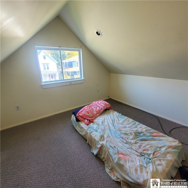 carpeted bedroom with lofted ceiling