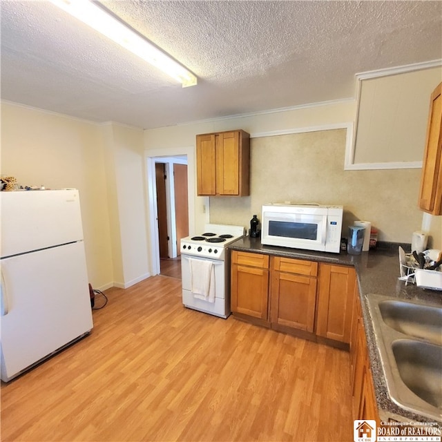 kitchen featuring light hardwood / wood-style flooring, a textured ceiling, sink, and white appliances