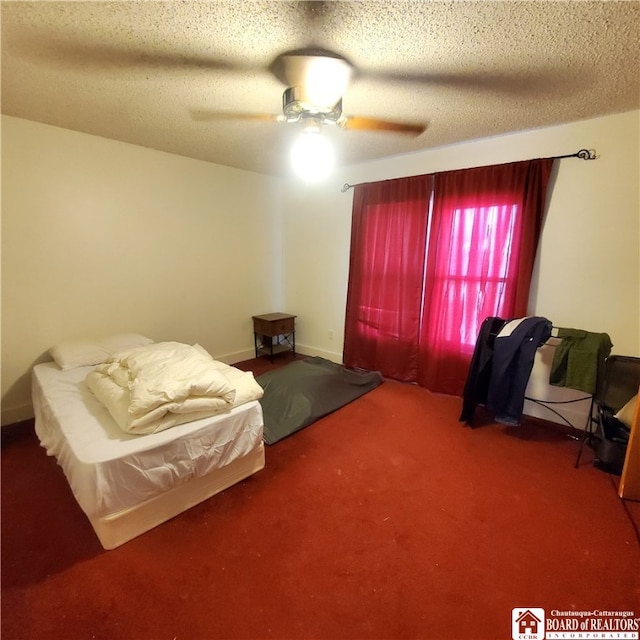 carpeted bedroom with ceiling fan and a textured ceiling