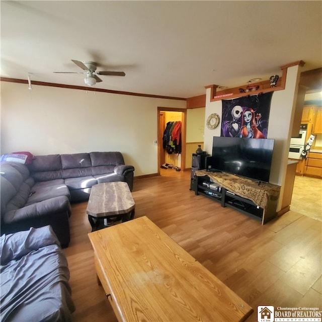 living room featuring crown molding, hardwood / wood-style floors, and ceiling fan