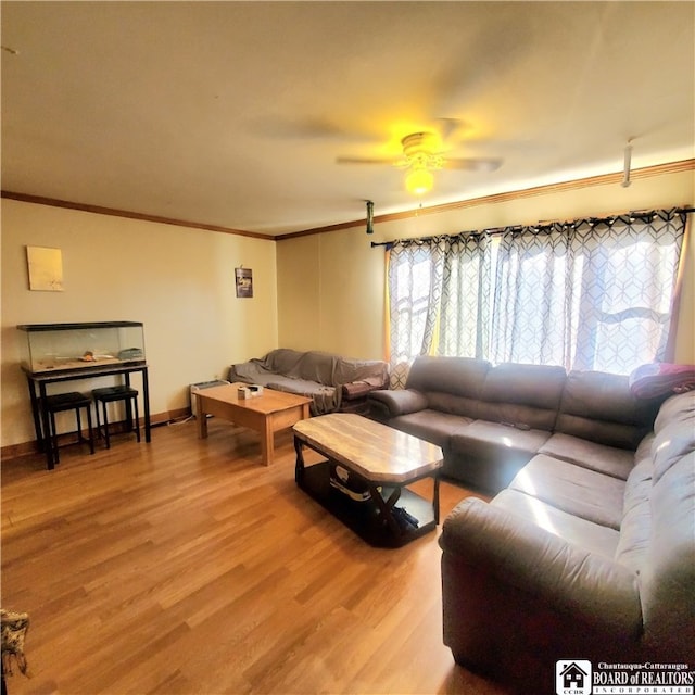 living room featuring ornamental molding, light wood-type flooring, and ceiling fan