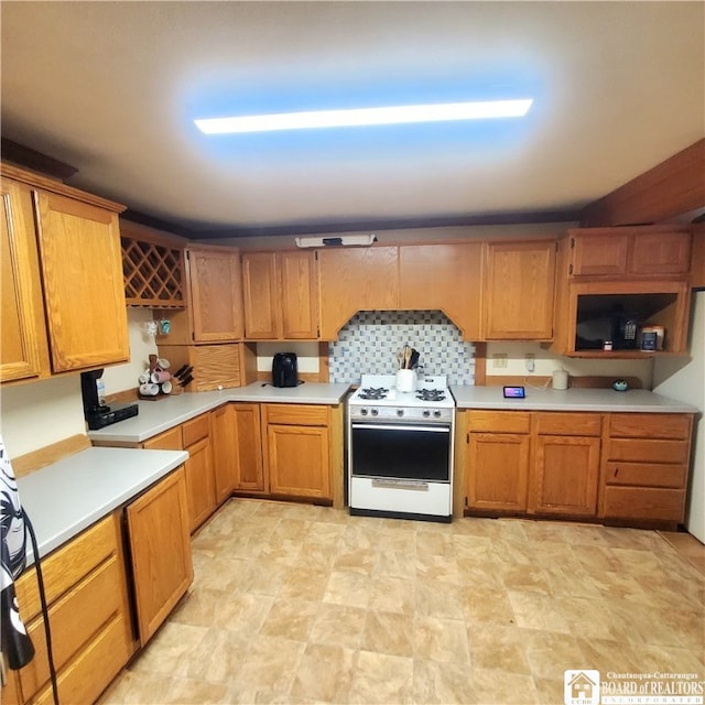 kitchen featuring decorative backsplash and white range with gas stovetop