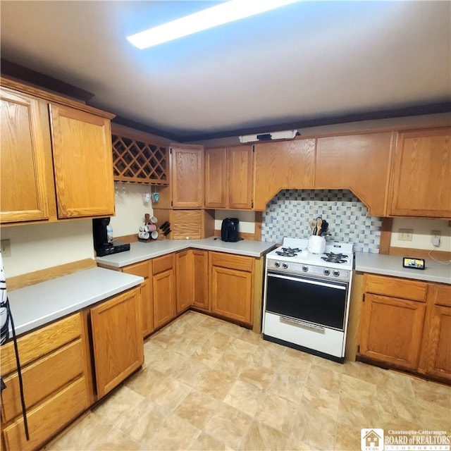 kitchen with backsplash and white range with gas stovetop