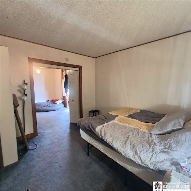 bedroom with a closet, a textured ceiling, and dark colored carpet