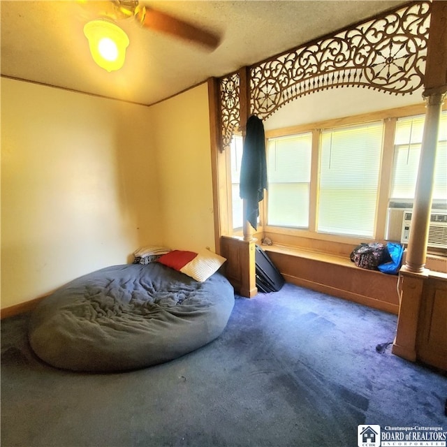 carpeted bedroom with multiple windows, a textured ceiling, cooling unit, and ceiling fan