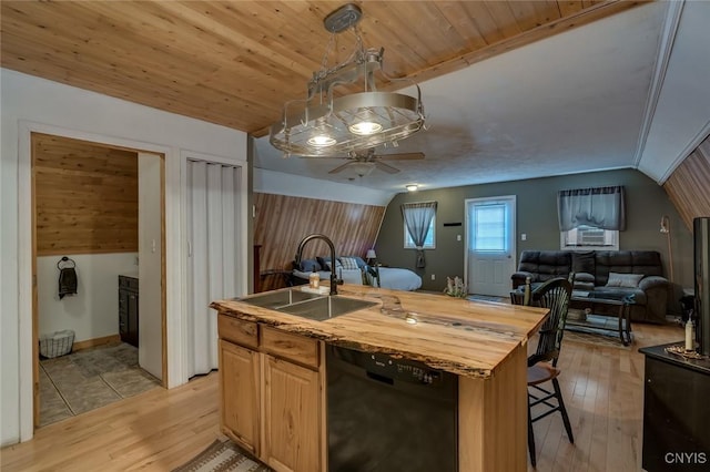 kitchen with pendant lighting, sink, butcher block countertops, dishwasher, and a kitchen island with sink