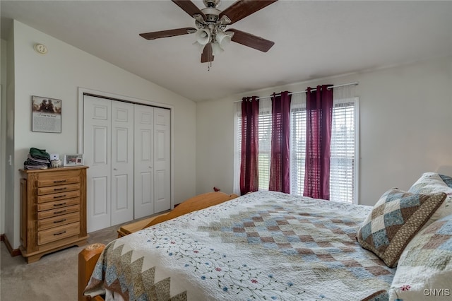 bedroom featuring lofted ceiling, light carpet, ceiling fan, and a closet