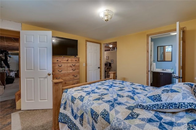 bedroom featuring connected bathroom, a spacious closet, sink, and a closet