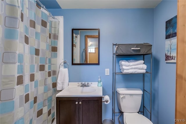 bathroom with vanity, curtained shower, and toilet