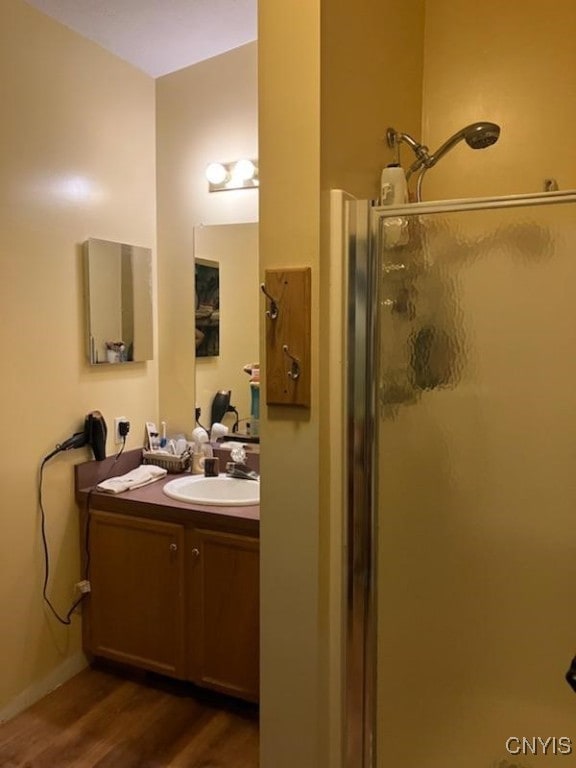 bathroom featuring a shower with door, vanity, and hardwood / wood-style floors