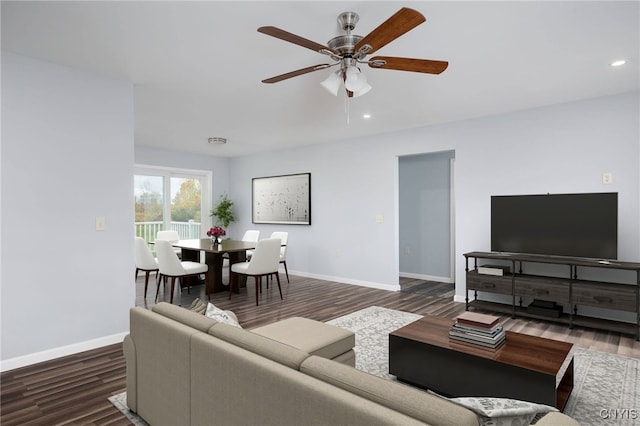 living room with ceiling fan and dark hardwood / wood-style flooring