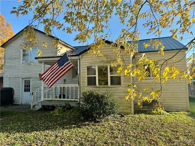 rear view of property featuring a yard