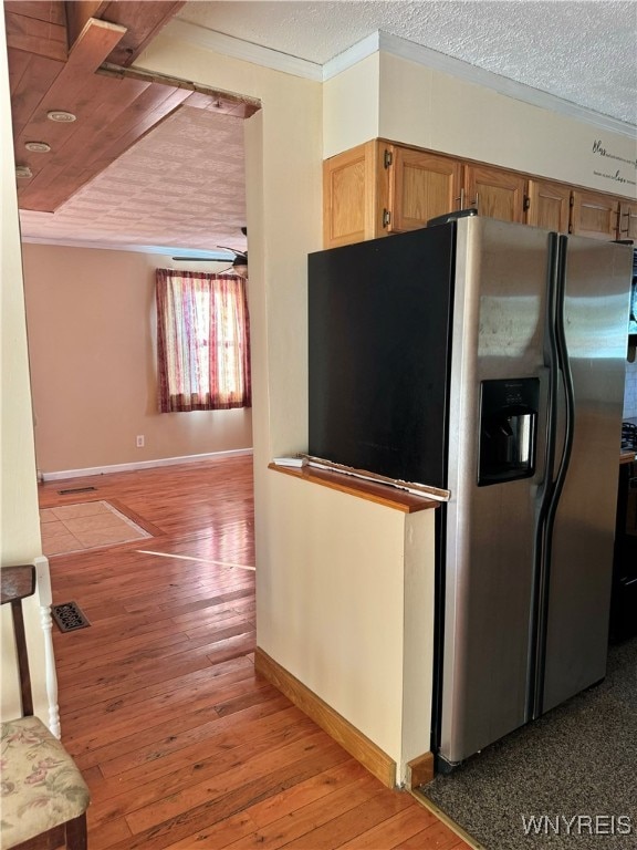 kitchen with ornamental molding, a textured ceiling, and light wood-type flooring