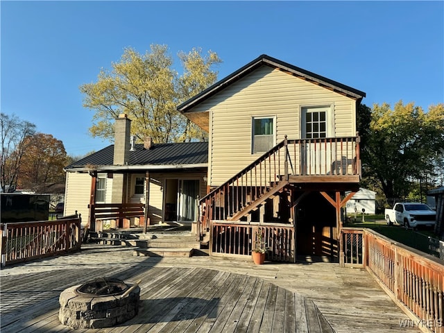 back of house featuring a deck and an outdoor fire pit