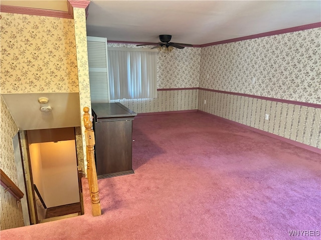 empty room featuring crown molding, carpet floors, and ceiling fan