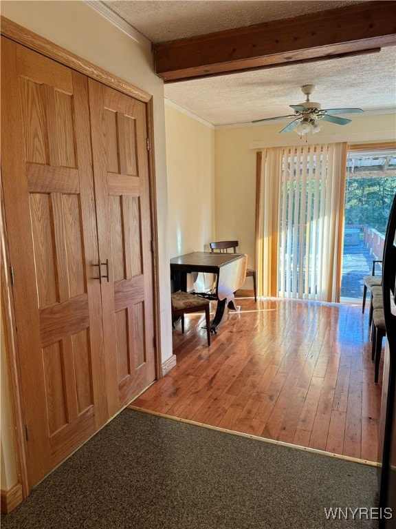 interior space featuring beam ceiling, hardwood / wood-style floors, a textured ceiling, and ceiling fan