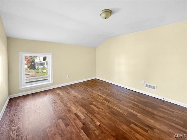 spare room with wood-type flooring and vaulted ceiling