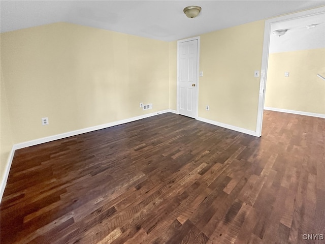 unfurnished room with lofted ceiling and dark wood-type flooring