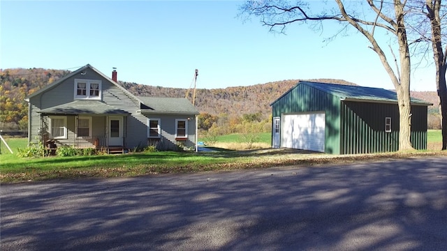 view of front of property featuring a mountain view, covered porch, and a garage