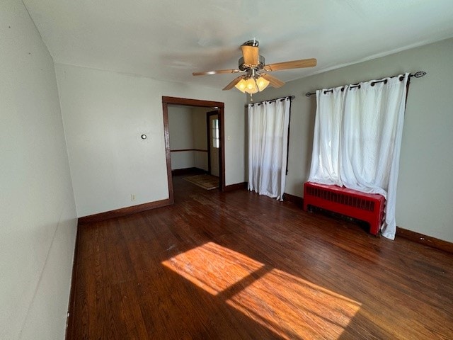 empty room with dark hardwood / wood-style floors and ceiling fan