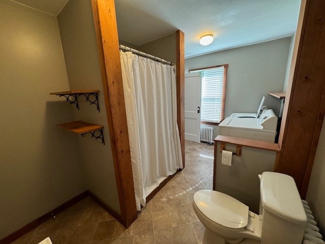 bathroom featuring radiator, toilet, and washing machine and dryer