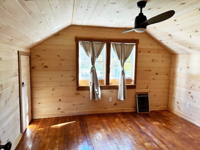 additional living space with wood ceiling, wood-type flooring, vaulted ceiling, and wooden walls