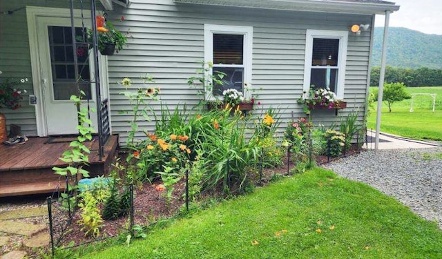 view of side of home featuring a yard and a deck