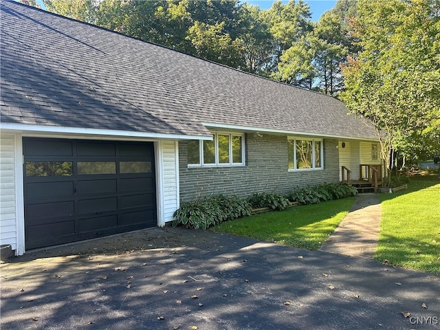 single story home featuring a front lawn and a garage