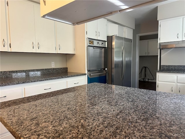 kitchen with dark stone countertops, appliances with stainless steel finishes, and white cabinets