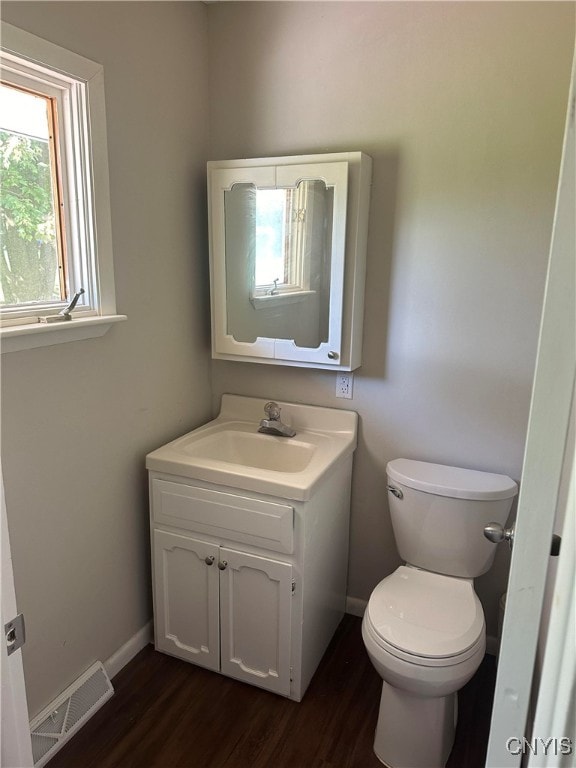 bathroom with vanity, toilet, and wood-type flooring