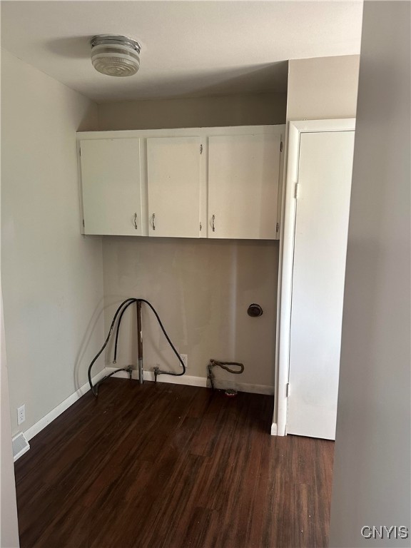 laundry room featuring cabinets, hookup for a washing machine, and dark wood-type flooring