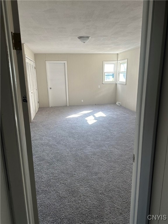 carpeted spare room with a textured ceiling