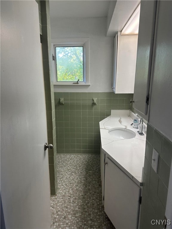 bathroom with tile walls, vanity, and tile patterned floors