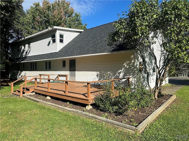 rear view of house with a deck and a lawn