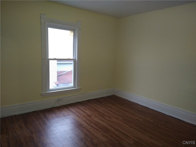 unfurnished room with dark hardwood / wood-style flooring