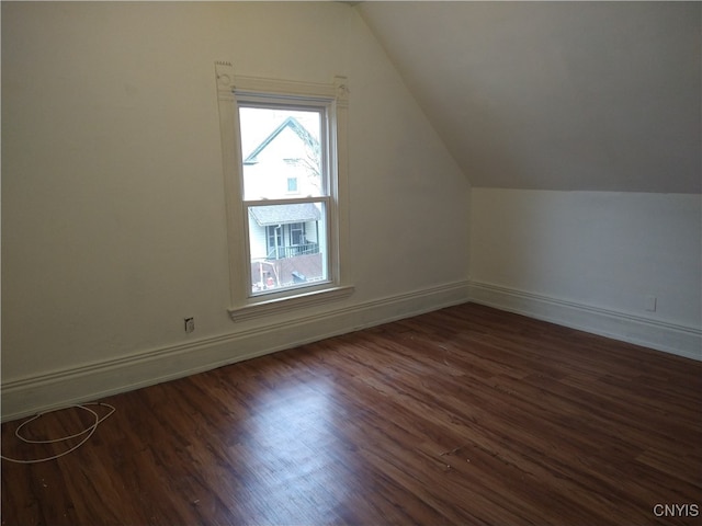 additional living space with vaulted ceiling and dark hardwood / wood-style flooring