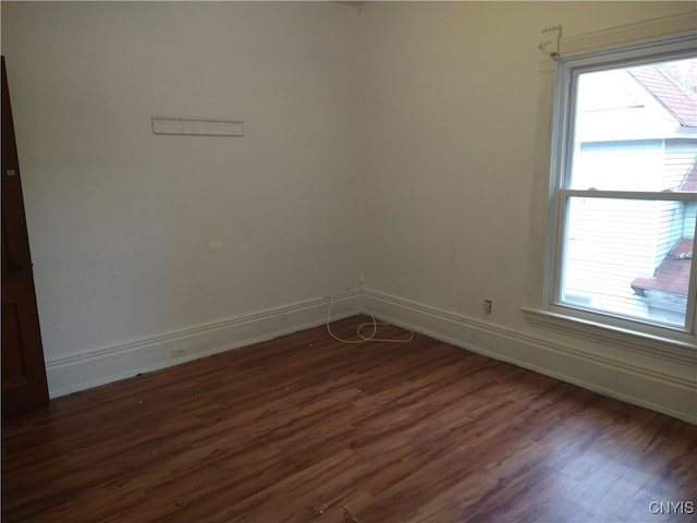 unfurnished room featuring dark hardwood / wood-style floors and plenty of natural light