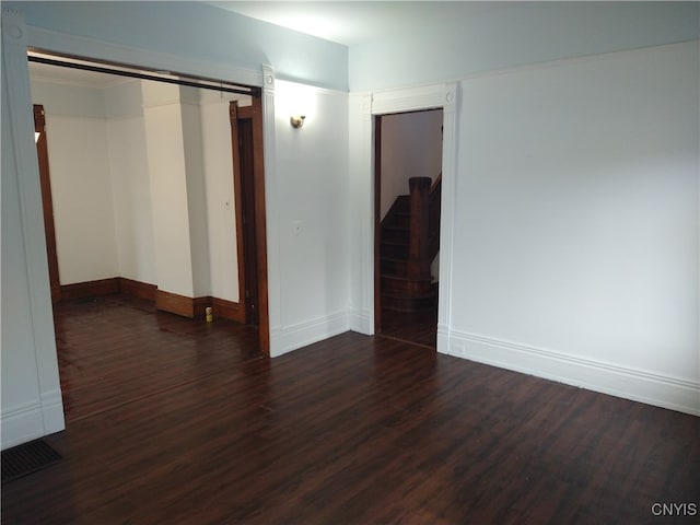 spare room with a barn door and dark hardwood / wood-style floors