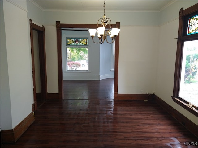 unfurnished dining area with ornamental molding, an inviting chandelier, and dark hardwood / wood-style flooring