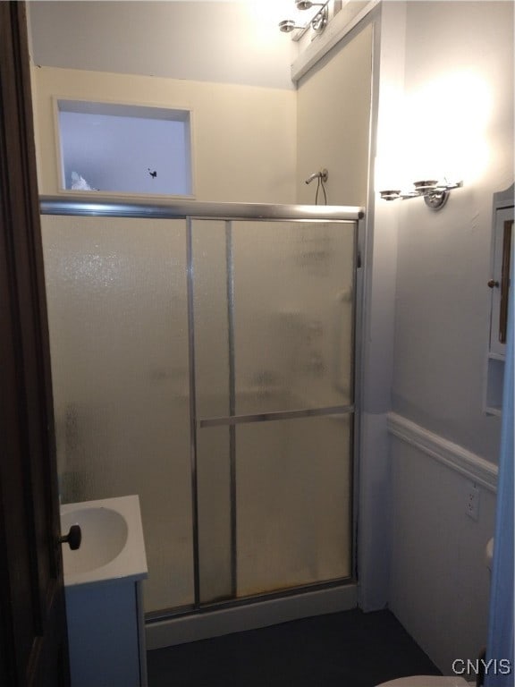 bathroom with vanity and a shower with door