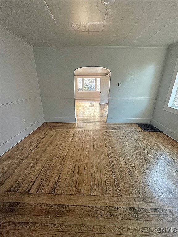 empty room featuring ornamental molding and hardwood / wood-style floors