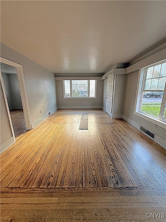 unfurnished living room with light hardwood / wood-style floors and a wealth of natural light