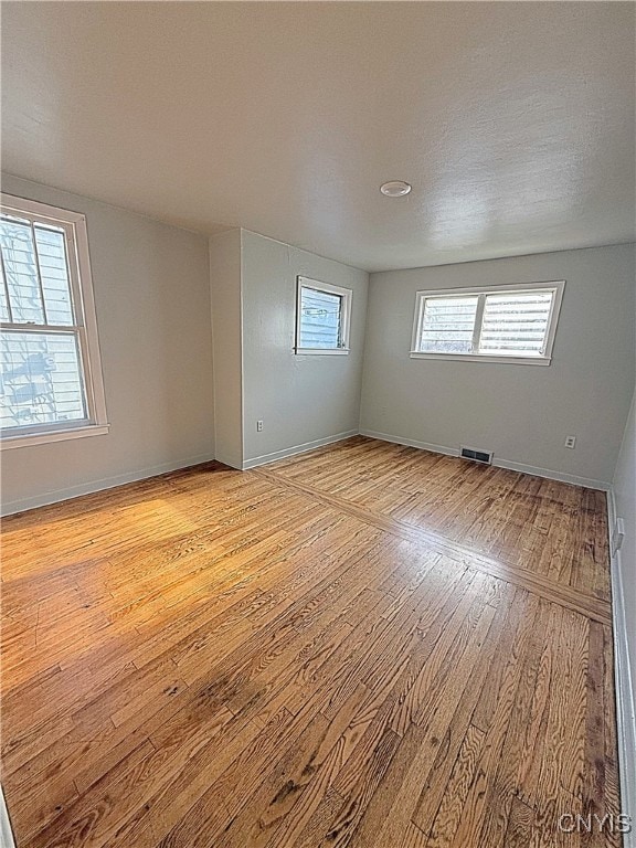 empty room with light hardwood / wood-style flooring and a textured ceiling