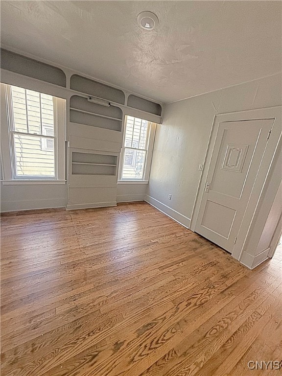 spare room with a textured ceiling and light wood-type flooring