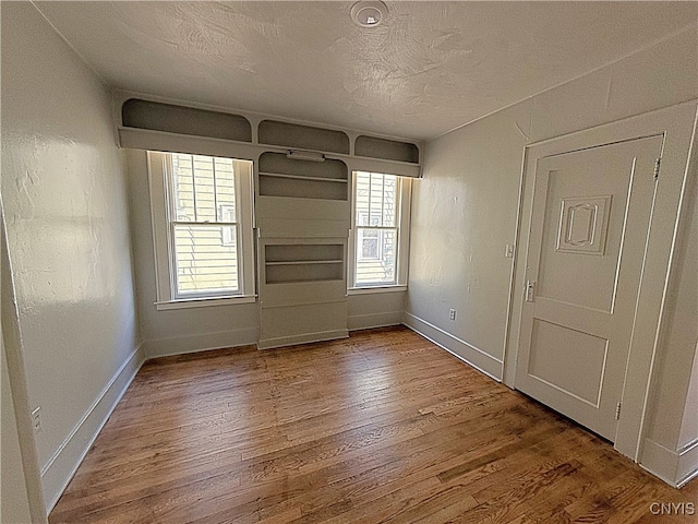 empty room featuring hardwood / wood-style flooring, a textured ceiling, and a wealth of natural light